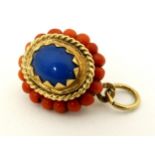 A yellow metal pendant set with coral and blue cabochon with rope twist detail indistinctly marked