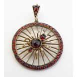 A yellow metal pendant formed as a spiders web with spider to centre set with garnets.