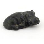 A carved green soapstone model of a recumbent hippo,