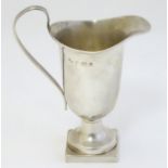 A silver helmet shaped cream jug on squared foot with reeded handle,