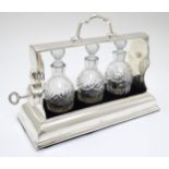 A 21stC silver plate small tantalus with 3 cut glass bottles and stoppers.