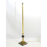 A brass standard lamp having grey marble sphere to column and a squared marble base.