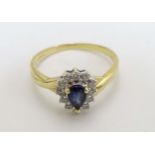 An 18ct gold ring set with central blue stone bordered by diamonds CONDITION: