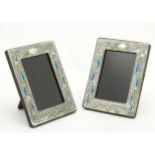 A pair of Art Nouveau style photograph frames with enamel decoration. 7 1/2" x 5 3/4" overall.