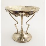 An Arts & Crafts silver plated tazza on three tendril formed legs, approx. 7 1/4" high.