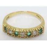 An 18ct gold half eternity ring set with green and white stones CONDITION: Please