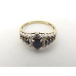 A 9ct gold ring set with blue stones and diamonds.