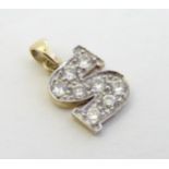 A 9ct gold pendant / charm formed as the letter 'S' and profusely set with white stones ½” long
