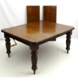 An Edwardian oak extending dining table with canted corners and reeded edge,