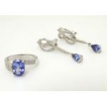 An 18ct white gold ring set with oval facet cut tanzanite flanked by diamonds,