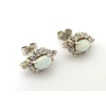 Silver stud earrings set with white stones and opals.