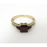 A 9ct gold ring set with central garnets flanked diamonds CONDITION: Please Note -