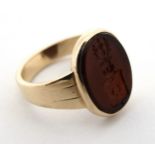 A yellow metal signet ring with set with oval cornelian seal with engraved armorial crest