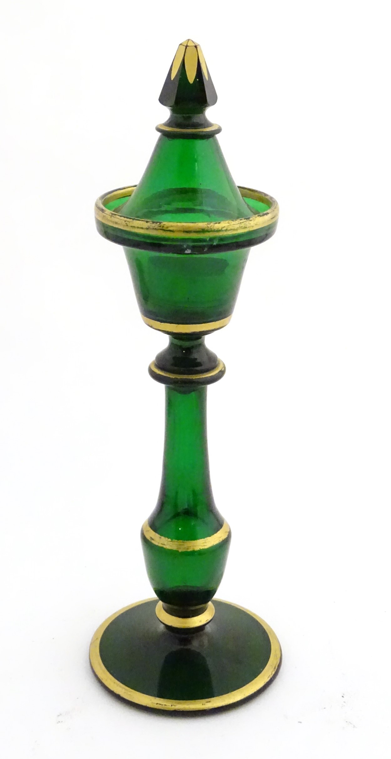 A Victorian tea light holder with a conical snuffer of green glass with gilded decoration, approx.