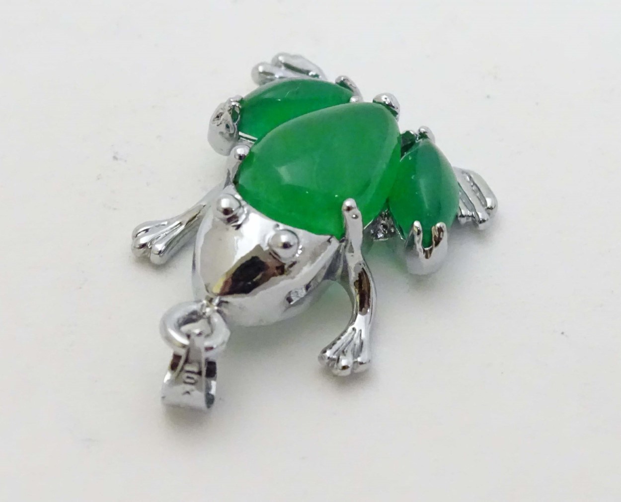 A white metal pendant formed as a frog set with green jade like cabochon 1" long - Image 6 of 6