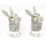 A pair of novelty white metal pepperettes formed as rabbit / hare heads 2 1/2" high