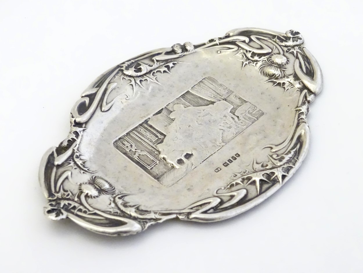 A silver pin dish with thistle decoration to border and interior scene to centre. - Image 4 of 5