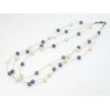 A silver three strand necklace set with various coloured pearls.