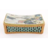 A Chinese famille rose headrest with a gently sloped surface decorated with a landscape,