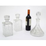 A pair of cut glass/ crystal decanters of squared form together with a ships decanter.