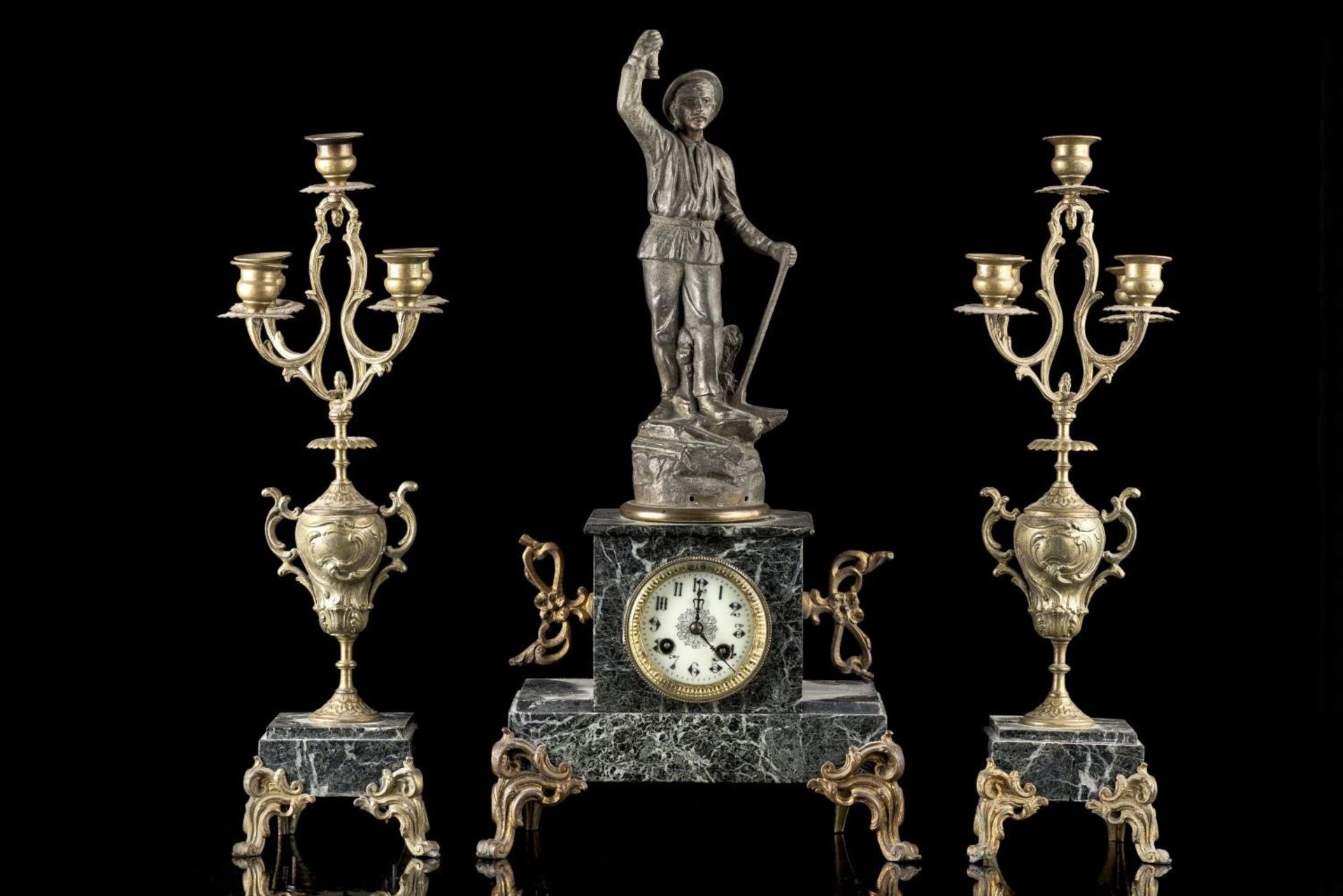 Garniture de cheminée en régule représentant un mineur sur une pendule à boîte [...]