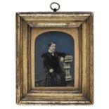 *Quarter-plate ambrotype of a seated boy against a blue background, 1860s, gilden wooden frame