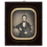 *Daguerreotype. A quarter-plate daguerreotype of a young man, 1850, half length, seated at a table