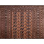 *Carpet. A modern woollen Bokhara carpet, with three rows of medallions on a red ground within