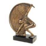 *Art Deco. Russian bronze modelled as a stylised athlete lifting a semi-globe with the letter 'n',