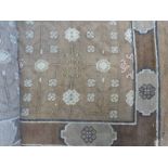 *Carpet. Large woollen carpet, from Eastern Turkestan, with a foliate design on a brown ground,