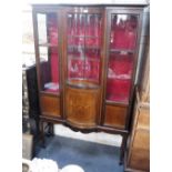 AN EDWARDIAN MAHOGANY GLAZED DISPLAY CABINET with central concave glazed door and a bowfronted