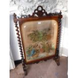 A VICTORIAN ROSEWOOD FIRE SCREEN with a needlework panel depicting figures in a religious scene, 41"