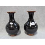 A PAIR OF CLOISONNE VASES decorated with repeated motifs against a black ground with polished copper