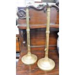 A PAIR OF TALL 19TH CENTURY BRASS CANDLESTICKS on circular bases, 20" high