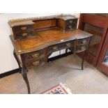 A VICTORIAN MAHOGANY WRITING DESK with carved decoration, on cabriole legs with an inset brown