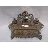 A 19TH CENTURY BRASS INKSTAND with all over pierced decoration, 15" wide