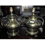 A PAIR OF ART NOUVEAU STYLE BRASS TABLE LAMPS with scrolled handles on a circular base on raised