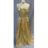 A FULL LENGTH YELLOW BROCADE EVENING DRESS, the rouched fitted bodice falling into a full skirt,