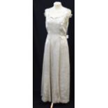 A CREAM AND SILVER LUREX THREADED EVENING DRESS, the fitted bodice with strap sleeves