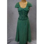 A FINE GREEN LACE PARTY DRESS, the fitted bodice decorated with sequins, falling into an 'A'-line