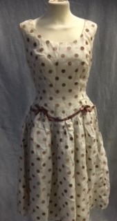 A CREAM AND LIGHT BROWN SPOTTED FLOCK NYLON PARTY DRESS, the waistline with brown satin trim,