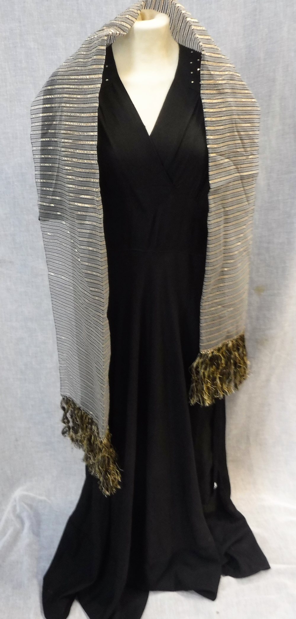 A FULL LENGTH BLACK CREPE EVENING DRESS, the shoulders and sleeves decorated with clear beadwork,