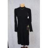 A BLACK LONG SLEEVE DAY DRESS, the bodice with side button detail, the skirt falling into pleats