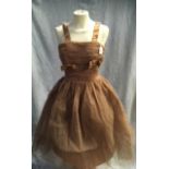 A COFFEE COLOURED TULLE PARTY DRESS, the rouched body decorated with satin bows and shoulder straps,