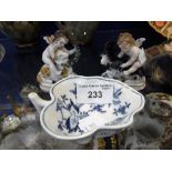 A PAIR OF CONTINENTAL FIGURES OF PUTTI RIDING GOATS, 7cm high and a blue and white leaf-shaped dish