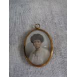 AN EARLY 19TH CENTURY PORTRAIT MINIATURE OF A LADY, head and shoulders on ivory, in an oval gilt