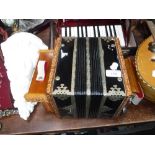A RUSSIAN ACCORDIAN (squeeze box) with carved wooden decoration fitted two bells