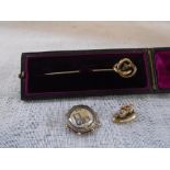 AN UNMARKED YELLOW METAL HAT-PIN in a fitted presentation case a lion charm and a gilt enamelled