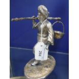 AN INDIAN WHITE METAL STUDY OF A MAN WEARING A TURBAN carrying a basket, 15.5 cm high