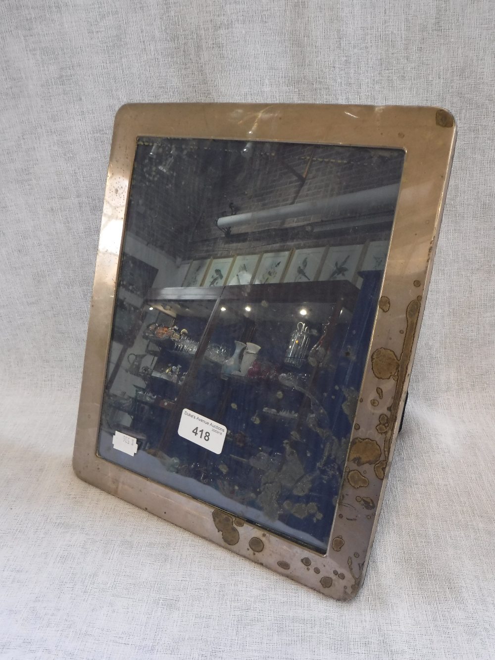 AN UNMARKED WHITE METAL PHOTOGRAPH FRAME, with easel back, 25cms x 30.5cms
